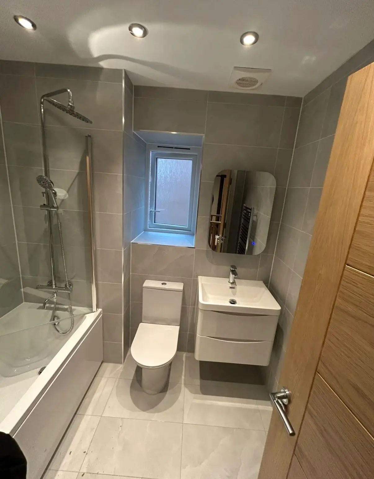 Finished bathroom with bath, basin and tiled walls