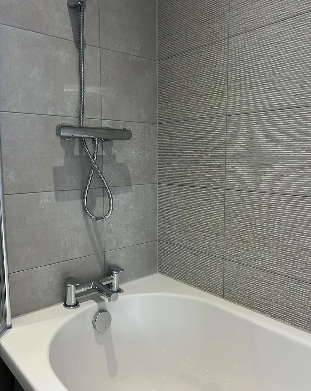Bath meeting a tiled wall with a clean sealant line